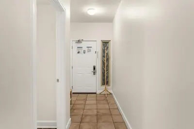 a hallway with a white door and a tile floor at Shores of Panama Beachfront 2nd Floor Unit 208! No elevators needed! in Panama City Beach