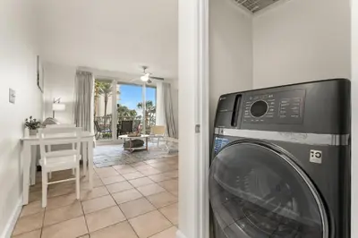 a washer and dryer in a room with a kitchen at Shores of Panama Beachfront 2nd Floor Unit 208! No elevators needed! in Panama City Beach
