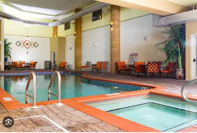 a pool at a hotel with chairs and tables at Shores of Panama Beachfront 2nd Floor Unit 208! No elevators needed! in Panama City Beach