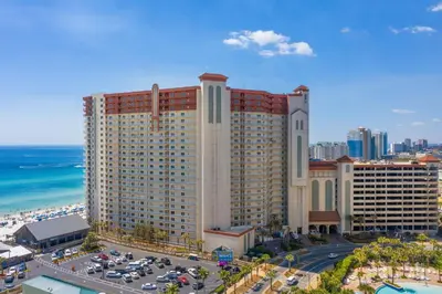 a large building with cars parked in a parking lot at Shores of Panama Beachfront 2nd Floor Unit 208! No elevators needed! in Panama City Beach