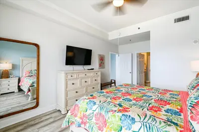 a bedroom with a bed and a dresser and a mirror at Laketown Wharf 2123 condo in Panama City Beach