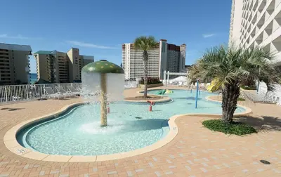 a fountain in the middle of a pool with palm trees at Laketown Wharf 2123 condo in Panama City Beach