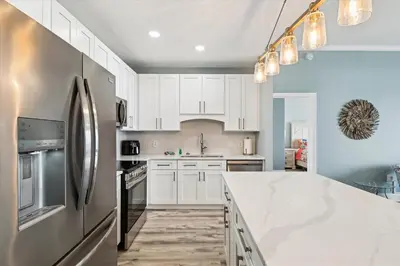 a kitchen with white cabinets and a stainless steel refrigerator at Laketown Wharf 2123 condo in Panama City Beach
