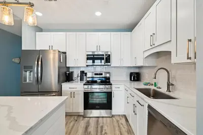 a kitchen with white cabinets and stainless steel appliances at Laketown Wharf 2123 condo in Panama City Beach
