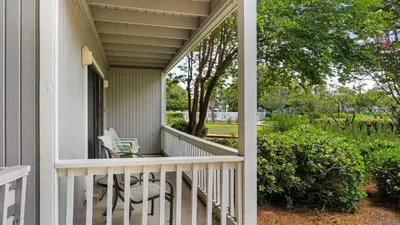 a porch with two chairs and a table at Beachwood Villas 1C in Santa Rosa Beach