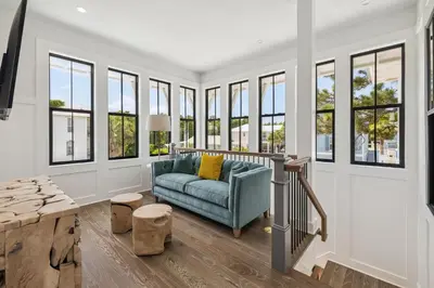 a living room with a blue couch and windows at White Sand Retreat by 30A Escapes in Seagrove Beach