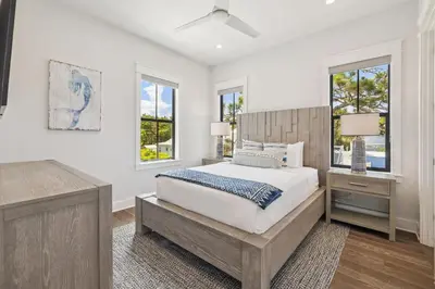 a white bedroom with a bed and two windows at White Sand Retreat by 30A Escapes in Seagrove Beach