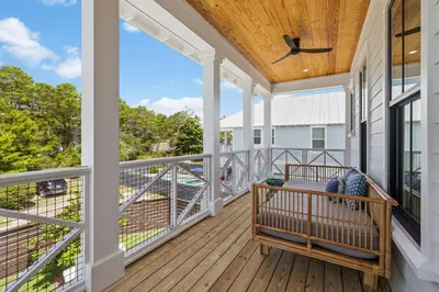 a porch with a bench on a wooden deck at White Sand Retreat by 30A Escapes in Seagrove Beach