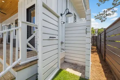 a wooden privacy fence next to a house at White Sand Retreat by 30A Escapes in Seagrove Beach