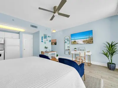 a bedroom with a white bed and a ceiling fan at New BeachFront-Majestic Beach Resort-Starbucks in Panama City Beach