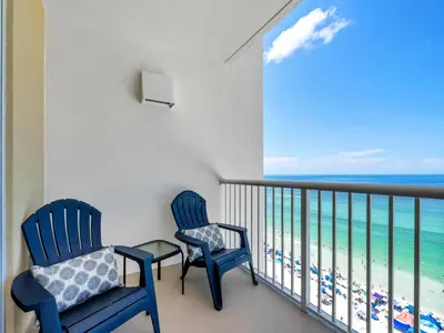 two blue chairs on a balcony with a view of the ocean at New BeachFront-Majestic Beach Resort-Starbucks in Panama City Beach