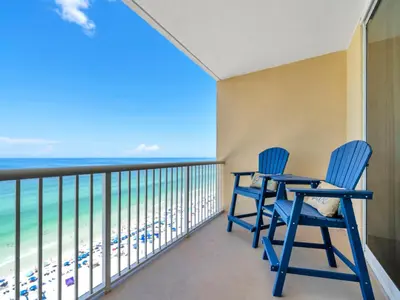 a balcony with two blue chairs and the ocean at New BeachFront-Majestic Beach Resort-Starbucks in Panama City Beach