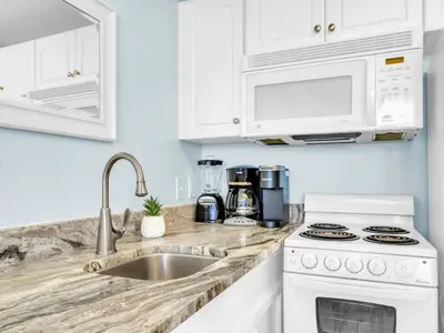 a kitchen with white cabinets and a sink at New BeachFront-Majestic Beach Resort-Starbucks in Panama City Beach