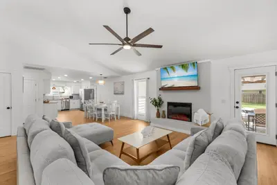 a living room with a large couch and a table at Salt Water POOL, GAME room, KING BED &PET friendly in Panama City
