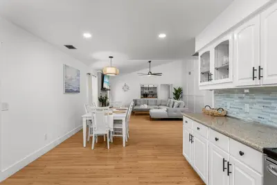 a kitchen and living room with a table and chairs at Salt Water POOL, GAME room, KING BED &PET friendly in Panama City