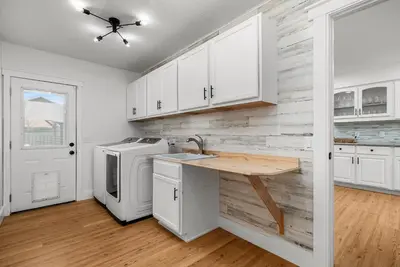 a kitchen with a sink and a washer and dryer at Salt Water POOL, GAME room, KING BED &PET friendly in Panama City