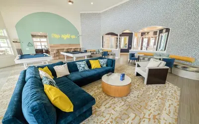 a living room with a blue couch and a table at 3 Bedroom Luxury Condo with Resort Pool, Game Room, and Gym in Panama City Beach