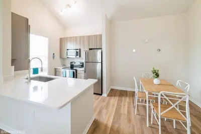 a kitchen and dining room with a table and chairs at 3 Bedroom Luxury Condo with Resort Pool, Game Room, and Gym in Panama City Beach