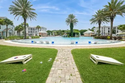 a large swimming pool with palm trees in the background at 3 Bedroom Luxury Condo with Resort Pool, Game Room, and Gym in Panama City Beach