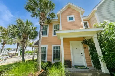 a pink house with palm trees in front of it at 3 Bedroom Luxury Condo with Resort Pool, Game Room, and Gym in Panama City Beach