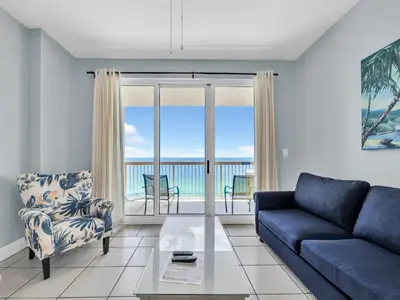 a living room with a couch and a view of the ocean at Sunrise Beach #1707 in Panama City Beach