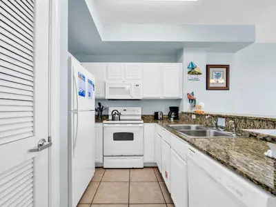 a white kitchen with a sink and a stove at Sunrise Beach #1707 in Panama City Beach