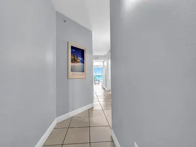 a hallway with white walls and a picture on the wall at Celadon 203 in Panama City Beach