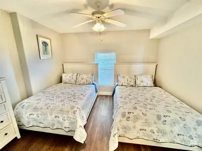 a bedroom with two beds and a ceiling fan at Tropic Winds 2108 in Panama City Beach