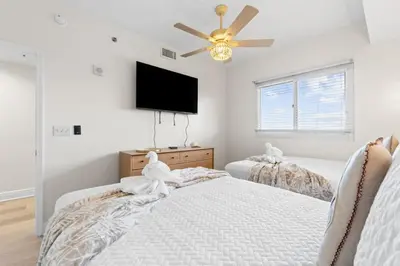 a bedroom with two beds and a flat screen tv at Sterling Breeze Unit 2106 in Panama City Beach