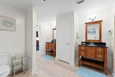 a bathroom with a toilet and a sink and a mirror at Sterling Breeze Unit 2106 in Panama City Beach