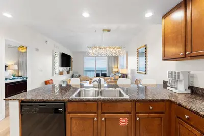 a kitchen with a sink and a living room at Sterling Breeze Unit 2106 in Panama City Beach