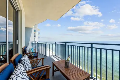 a balcony with two chairs and a table with a view of the ocean at Sterling Breeze Unit 2106 in Panama City Beach
