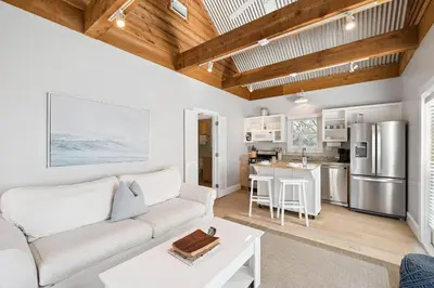 a living room with a white couch and a kitchen at 90 N Cartagena Carriage House by 30A Escapes in Rosemary Beach