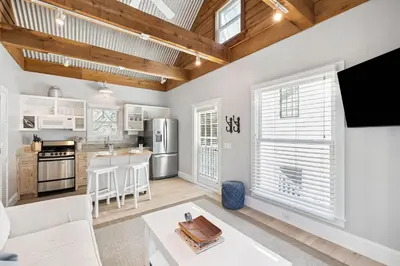 a kitchen and living room with white walls and wood ceilings at 90 N Cartagena Carriage House by 30A Escapes in Rosemary Beach