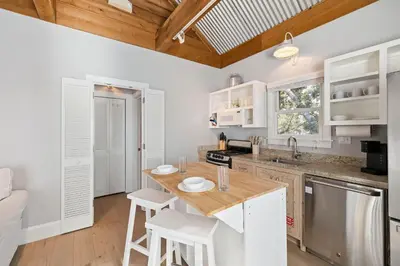 a kitchen with white cabinets and a wooden counter top at 90 N Cartagena Carriage House by 30A Escapes in Rosemary Beach