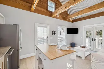 a kitchen with white walls and wooden ceilings at 90 N Cartagena Carriage House by 30A Escapes in Rosemary Beach