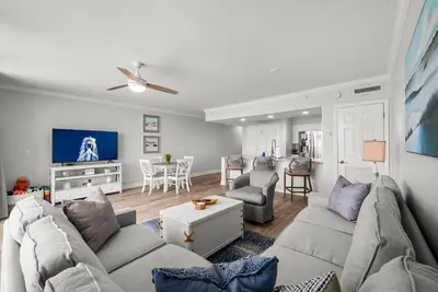 a living room with a couch and a tv at Emerald Beach Resort 1734 - Amazing Views, Beachfront, King Bed, 3 Pools, Starbucks in Panama City Beach