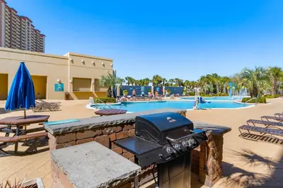 a outdoor grill in front of a swimming pool at Emerald Beach Resort 1734 - Amazing Views, Beachfront, King Bed, 3 Pools, Starbucks in Panama City Beach