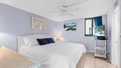 a bedroom with a white bed and a window at Sunbird Resort - 11th Floor - Free Beach Chairs - by Sunbird Rentals in Panama City Beach