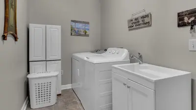a bathroom with a washing machine and a sink at Secluded Sanctuary By the Sea in Seacrest