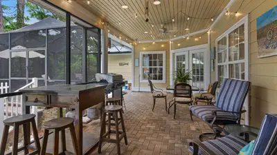 a screened in porch with a table and chairs at Secluded Sanctuary By the Sea in Seacrest