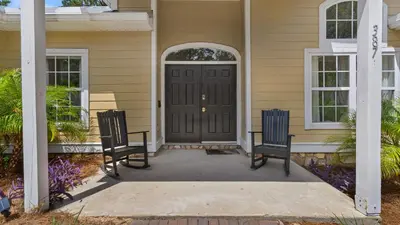 a front door of a house with two chairs at Secluded Sanctuary By the Sea in Seacrest