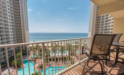 a balcony with a view of a pool and the ocean at Shores of Panama 816 by Emerald Coast Retreats in Panama City Beach