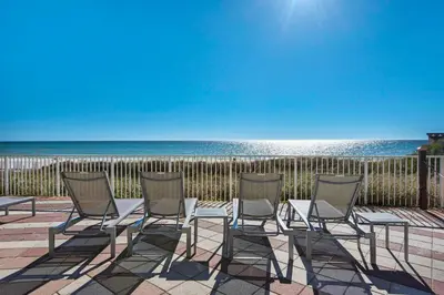 a group of chairs sitting on a patio near the beach at Shores of Panama 816 by Emerald Coast Retreats in Panama City Beach