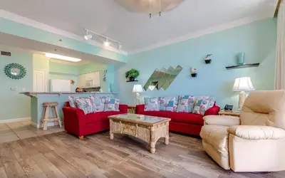 a living room with two red couches and a table at Shores of Panama 816 by Emerald Coast Retreats in Panama City Beach