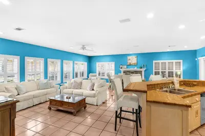 a kitchen and living room with blue walls at Little Narnia - Colorful Beach House Private Pool in Seacrest