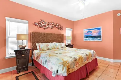 a bedroom with a large bed with orange walls at Little Narnia - Colorful Beach House Private Pool in Seacrest
