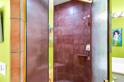 a shower with a glass door in a bathroom at Little Narnia - Colorful Beach House Private Pool in Seacrest