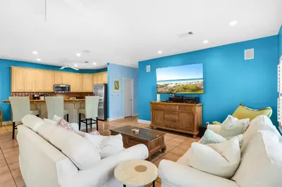a living room with white furniture and a blue wall at Little Narnia - Colorful Beach House Private Pool in Seacrest
