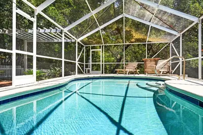 a swimming pool with a pergola and a swimming pool at Little Narnia - Colorful Beach House Private Pool in Seacrest